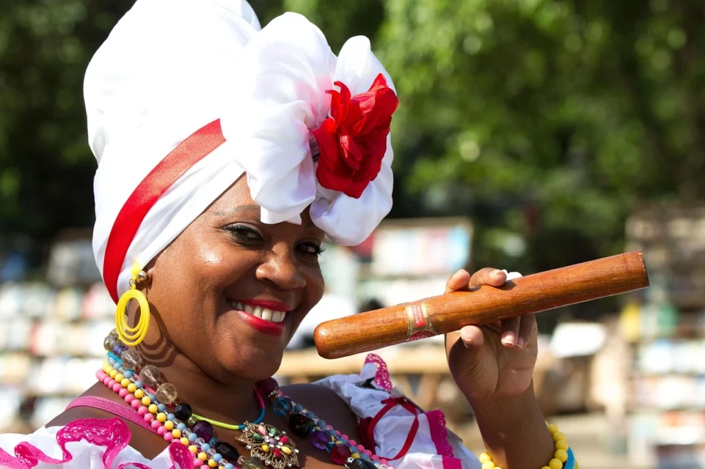 Mujer-cubana-y-tabaco Mujer cubana con tabaco en mano, representando la tradición cultural y la identidad de La Habana.