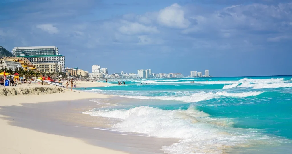 Playa de arena blanca con palmeras y mar turquesa en México.