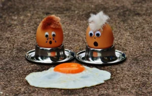Huevos frescos en cáscara sobre fondo de madera, ilustrando expresiones idiomáticas en español relacionadas con huevos