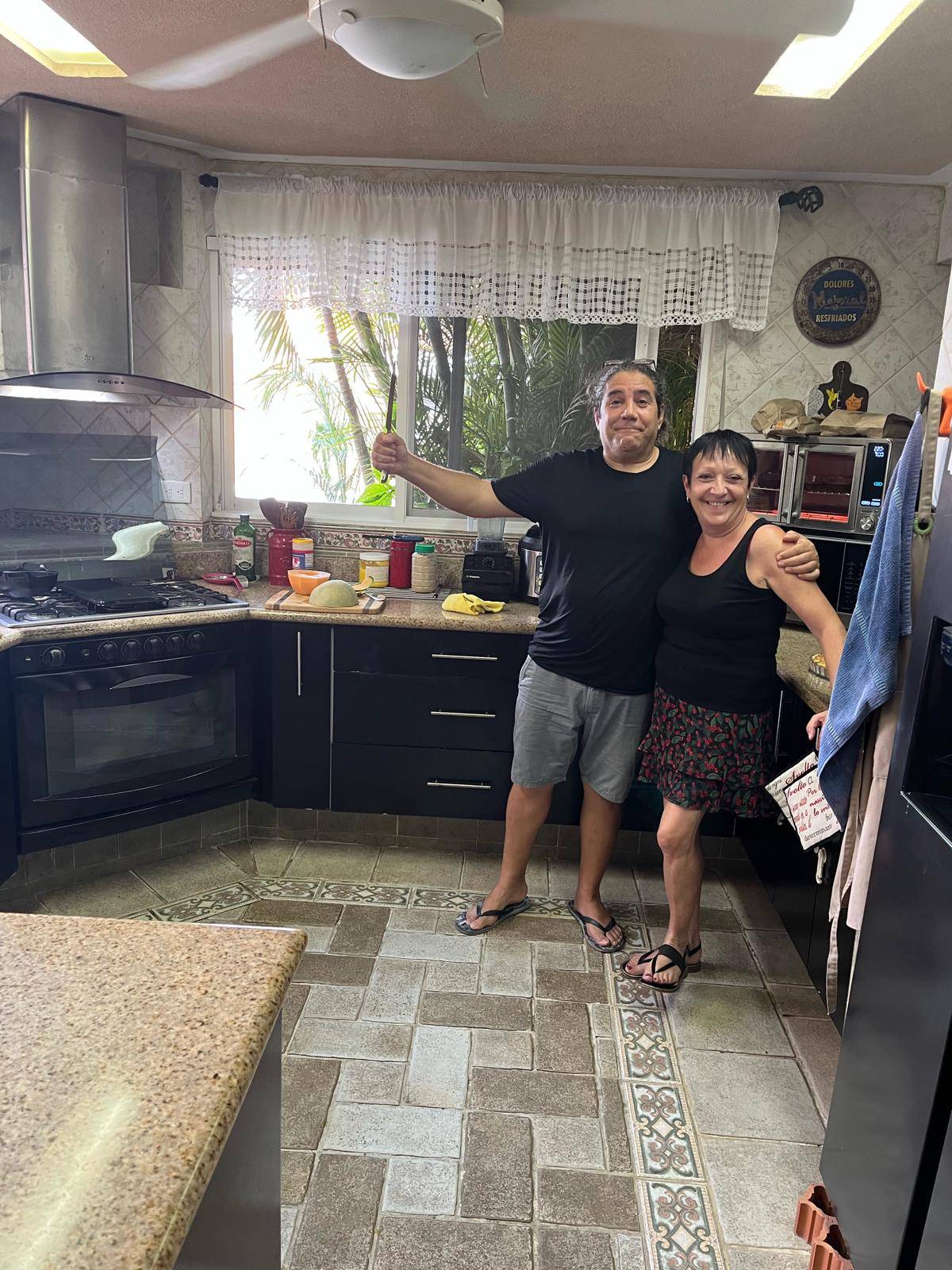 Françoise preparando un plato típico francés y explicando la receta en español durante una cena de intercambio cultural en Yucatán.